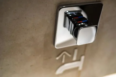 Chrome button to start tap water in public toilet Photos