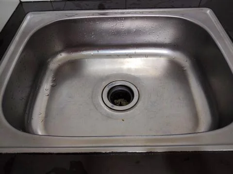 A chrome-colored sink in the kitchen area Stock Photos