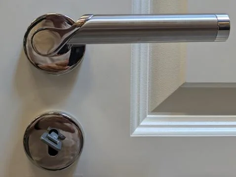 Chrome door handle and lock on white interior door with clean modern details Stock Photos