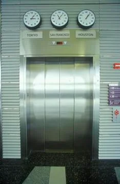 Chrome elevator doors &amp; world time zones, Cleveland International Airport Fotos de archivo