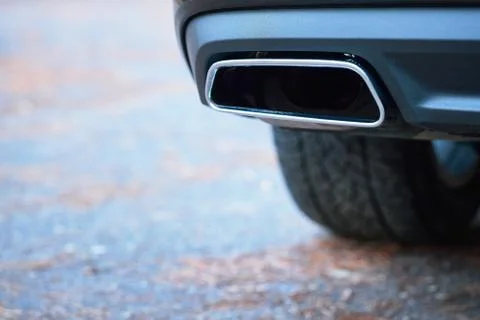 Chrome exhaust pipe selective focus of powerful luxury car with black bodywork Stock Photos