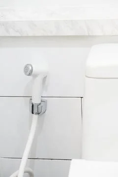 Chrome handheld shower head and wall bracket holder in a bathroom Stock Photos