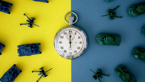 Chrome-plated mechanical stopwatch lies on yellow-blue background of colors of Stock Footage 171581663