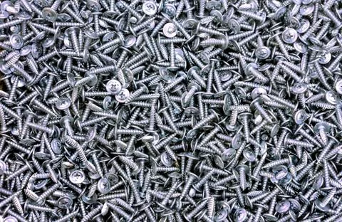 Chrome self-tapping screws on the counter of a hardware store. Stock Photos
