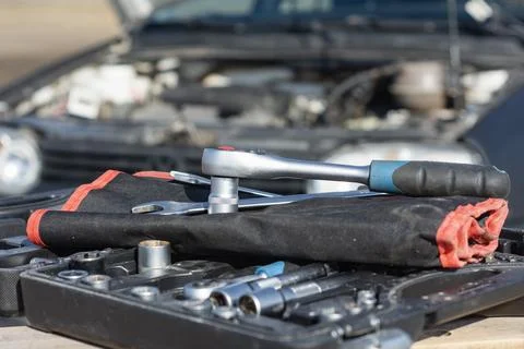 Chrome socket wrench and spanners on a black tool roll and organized toolbox. Stock Photos