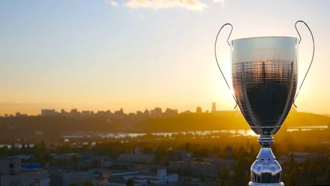 Chrome winner cup on the gold sunset in the city for sport competitions Stock Footage 76969366