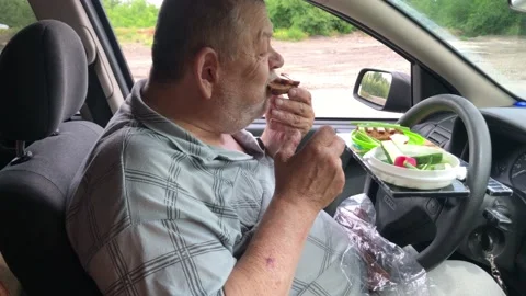 Chubby man healthy eating while sitting inside car on driver seat Video stock 157604366