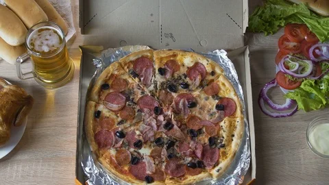 Chubby man sitting at table with harmful food and eating pizza with pleasure Video stock 81320297