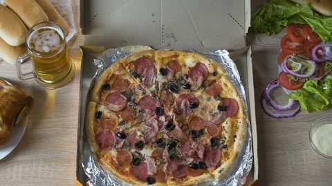 Chubby man sitting at table with harmful food and eating pizza with pleasure Video stock 81323899