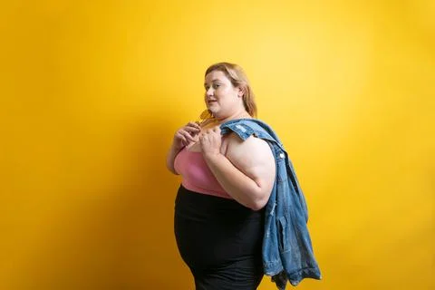 Chubby young Caucasian model posing with denim jacket, fat fashion 库存照片