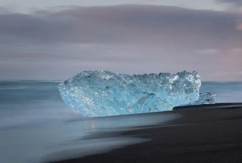 Chunk of ice washed ashore at the black sand beach of southern Iceland Stock Photos