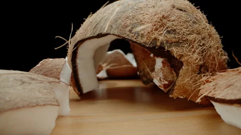 Chunks of a Broken Coconut Scattered on the Table, the Camera Passes Through The Stock Footage 253939116