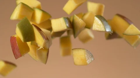 Chunks of fresh mango flying in slow motion.  Shot with Phantom Flex 4K camera. Stock Footage 130355899