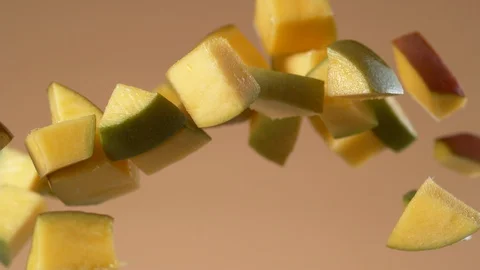Chunks of fresh mango flying in slow motion.  Shot with Phantom Flex 4K camera. Video stock 130355920