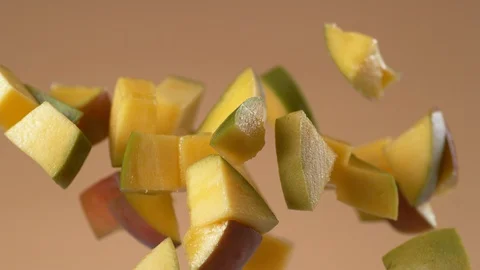 Chunks of fresh mango flying in slow motion.  Shot with Phantom Flex 4K camera. Stock Footage 130355937