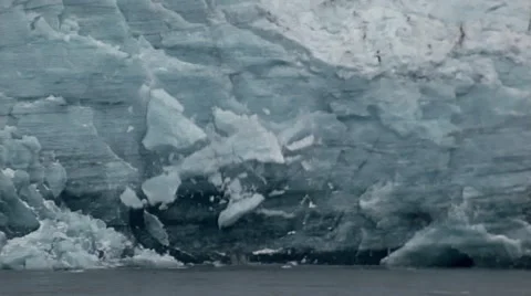 Chunks of ice fall from face of glacier to land in water at the foot. Stock Footage 67615850