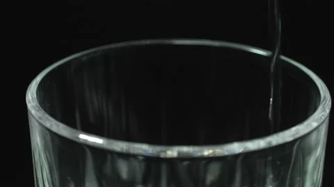 Chunks of ice fall into the glass. Ice cubes in a glass on a black background. Stock Footage 152178587