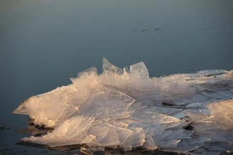 Chunks of ice on the river in the rays of the setting sun. Calm quiet environ Stock Photos