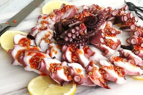 Chunks of octopus on a cutting Board Stock Photos