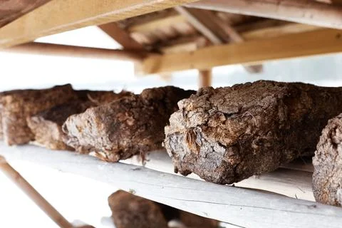 Chunks of peat piled up for drying on wooden shelf . Horizontal photo with bl Foto stock