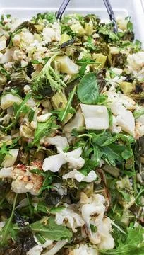 Chunks of roasted cauliflower, celery and other fresh green vegetables prepar Stock Photos