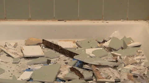 Chunks of tile fall to shower base as demolition begins. Video stock 35405698