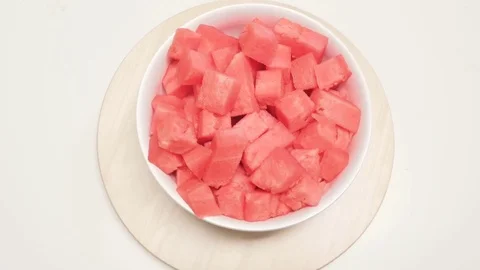 Chunks of Watermelon in a Ceramic Serving Bowl Spin on a Wooden Turntable Stock Footage 79384334