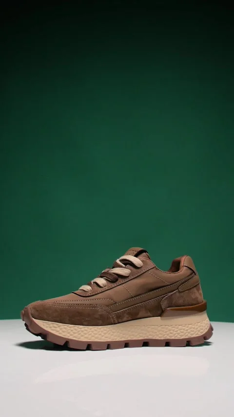 A chunky sneaker against a green background in rotation. Circular filming. Stock-Footage 310736962