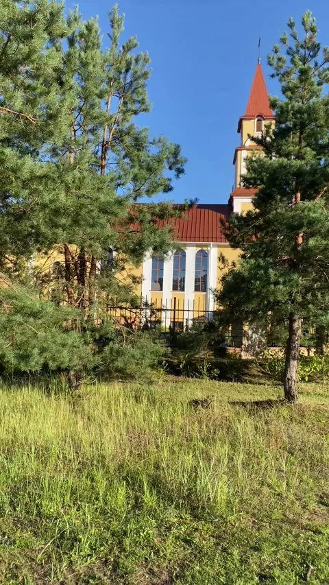 A church among the trees in a forest clearing. Vertical video Stock Footage 282182175