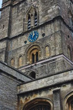 Church clock tower with blue clock face in the classic style in England Stock Photos