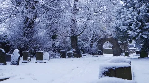 Church graveyard in winter as snow is falling Stock Footage 166579608