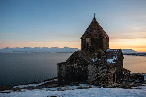 Church on lake sevan at sunset in armenia Stockfoto's