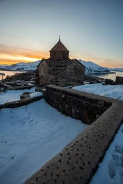 Church on lake sevan at sunset in armenia Stock Photos