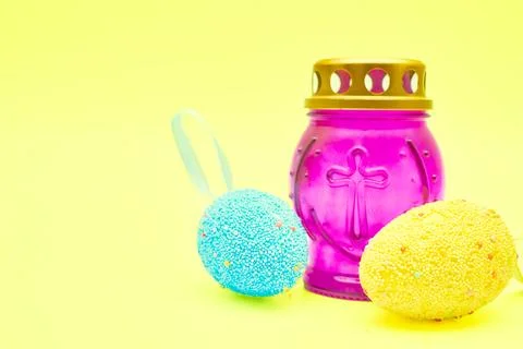 Church lamp candlestick with Easter eggs on a festive tender yellow background Stock Photos