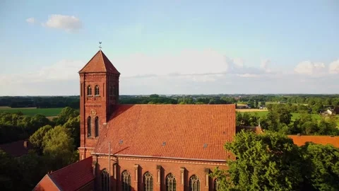 Church located in a rural area with fields and trees under a clear sky Stock Footage 339783039