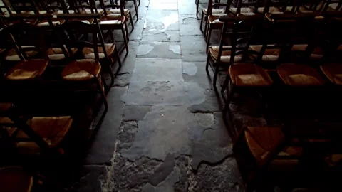 Church pews stand empty in the interior with soft light from stained glass .. Stock Footage 316587202