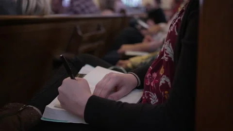Church pews taking notes on an open bible woman Stock Footage 171992675