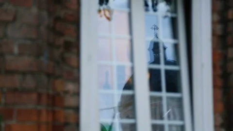Church reflected in window of private residence, devotion to religion, Christian Stock-Footage 84912125