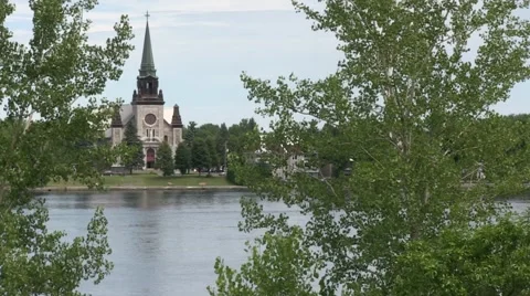 Church on river side with trees (St-Athanase, Iberville) Stock Footage 40975558