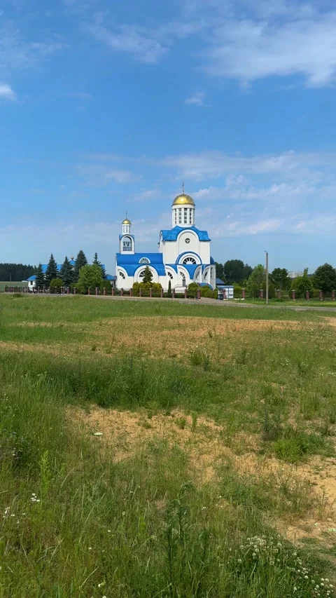 A church in a rural area is seen surrounded by green grass  Stockbeeldmateriaal 338179727