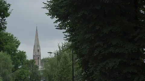 Church spire hidden by trees in leafy London suburb Stock Footage 90105933