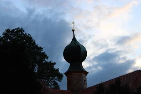 Church tower in front of evening clouds Foto stock