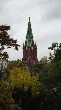 Church tower over treetops Stock Photos