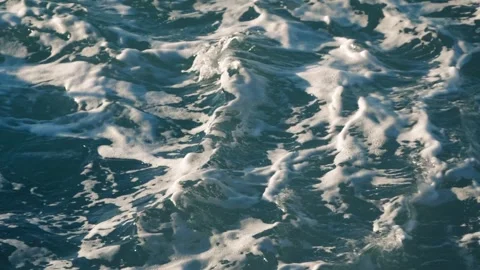 Churning ocean water creates vibrant white foam on surface waves Stock Footage 337410840