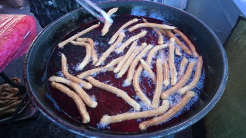 Churros Being Fried in a Large Pot in a Street Market Stock Footage 279031734