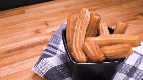 Churros Without Sugar Pan in Black Squared Bowl on Kitchen Rag Over Wood Video stock 128091647