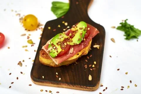 Ciabatta with avocado and different vegetables on a white background. Stock Photos