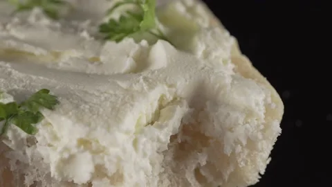 Ciabatta bread with curd cheese and herbs on black background Stock Footage 137709765