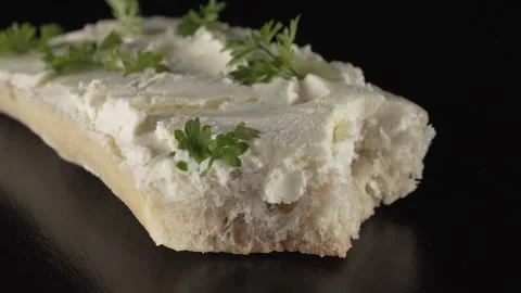 Ciabatta bread with curd cheese and herbs on black background Stock Footage 137710227