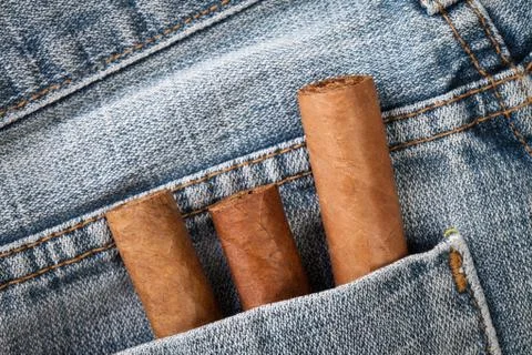 Cigar in the jeans pocket on back side Stock Photos